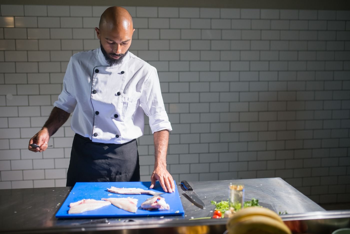 Chef filleting fish in a professional kitchen
