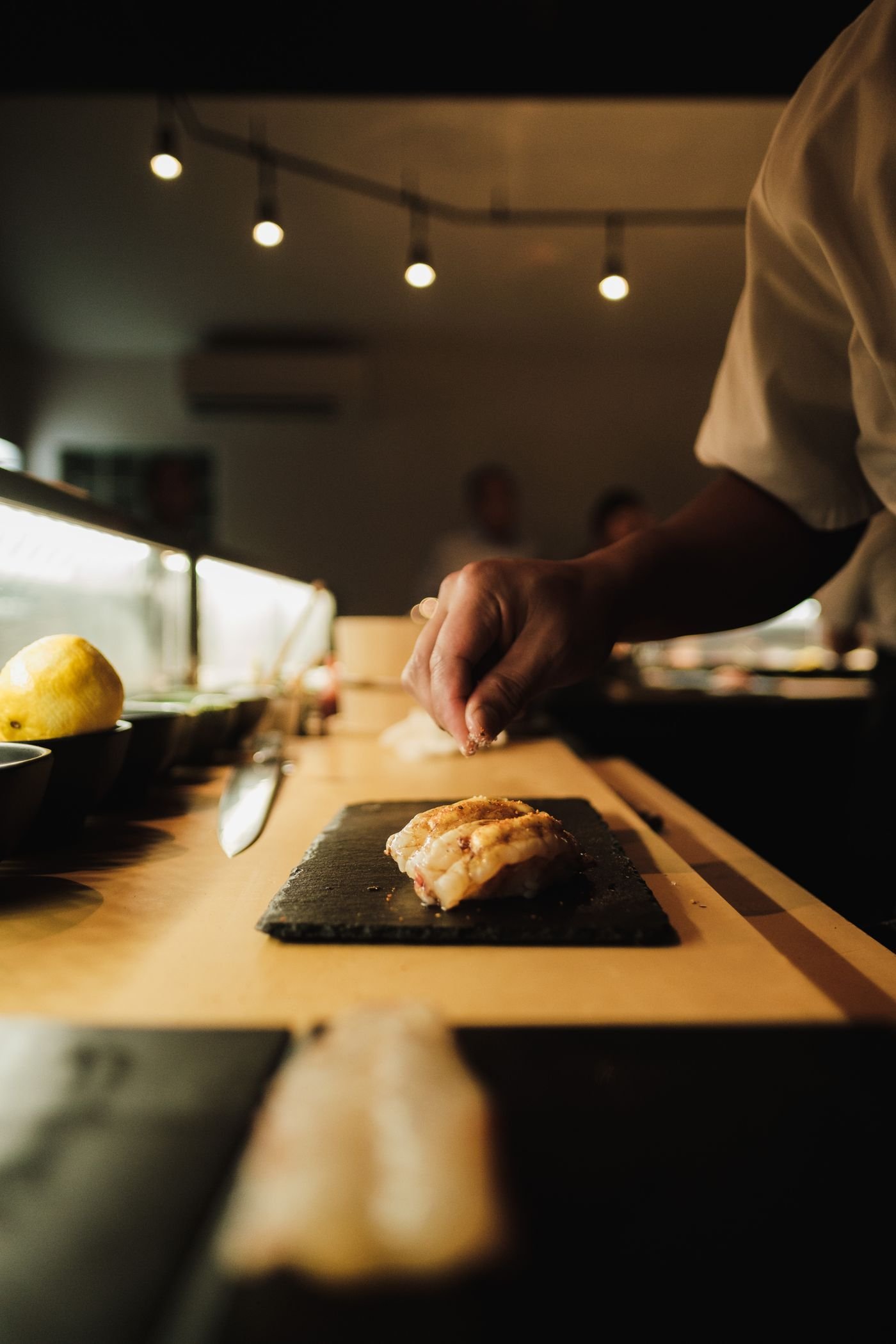 Chef preparing sushi at a restaurant counter